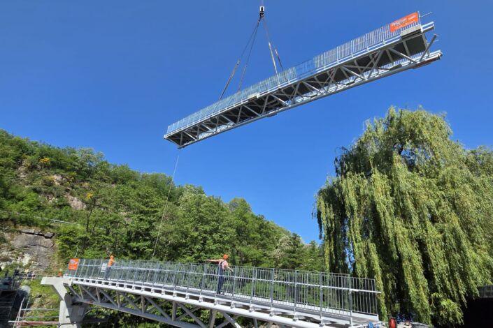 Montage einer 50 Meter langen Stahlbrücke mit Fachwerkkonstruktion per Kran