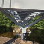 Unteransicht einer Stahlbrücke mit Fachwerkkonstruktion über einer Flussquerung