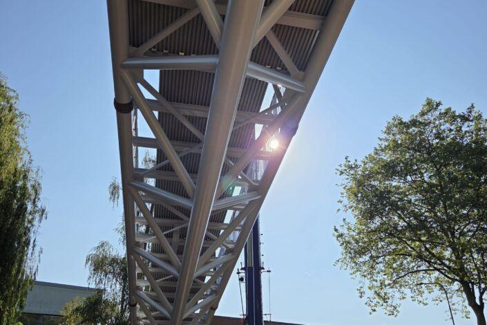 Unteransicht einer modernen Stahlbrücke mit Fachwerk und GFK Belag