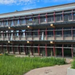 Fassadenansicht des Life Campus Hamburg mit Fluchtbalkonen, Geländern und farbigen Sonnenschutzelementen aus Stahl