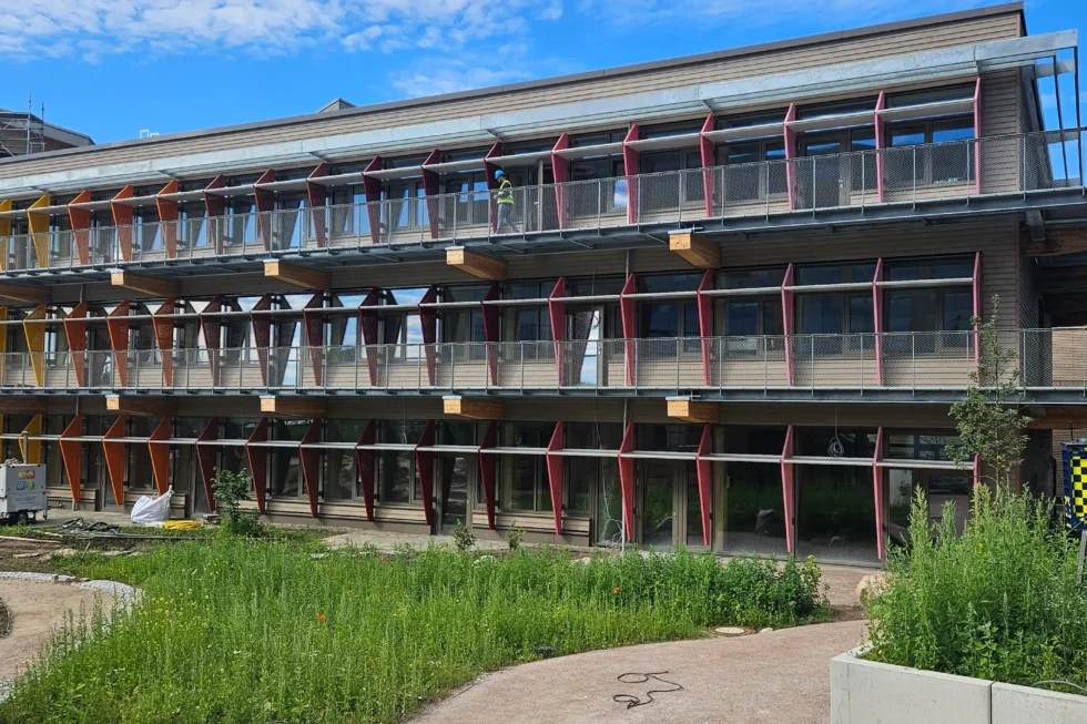Fassadenansicht des Life Campus Hamburg mit Fluchtbalkonen, Geländern und farbigen Sonnenschutzelementen aus Stahl