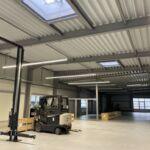 Innenansicht einer modernen Lager und Werkstatthalle mit Stahlkonstruktion, LED Beleuchtung und Dachlichtkuppeln