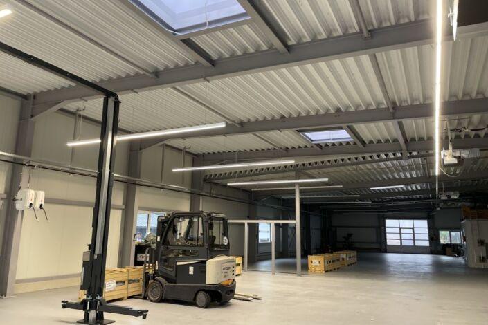 Innenansicht einer modernen Lager und Werkstatthalle mit Stahlkonstruktion, LED Beleuchtung und Dachlichtkuppeln