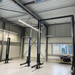 Werkstattbereich einer Stahlhalle mit Hebebühnen und moderner Gebäudeausstattung