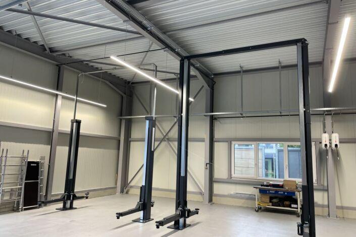 Werkstattbereich einer Stahlhalle mit Hebebühnen und moderner Gebäudeausstattung