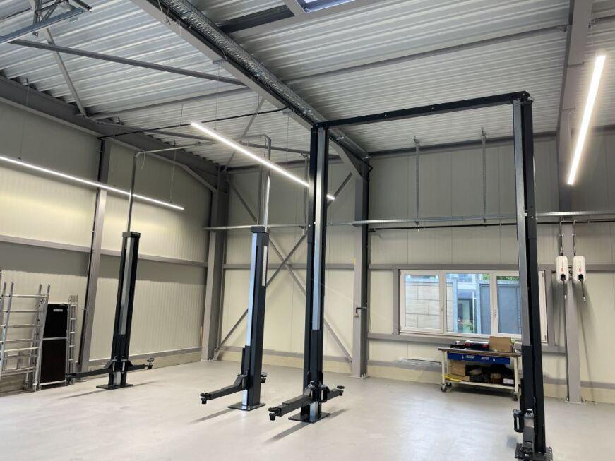 Werkstattbereich einer Stahlhalle mit Hebebühnen und moderner Gebäudeausstattung
